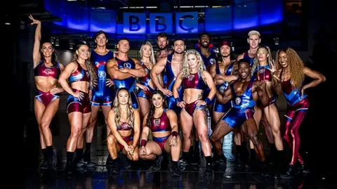 Guy Levy/BBC The cast of the BBC's Gladiators programme is pictured in their show costumes, standing outside the BBC's New Broadcasting House