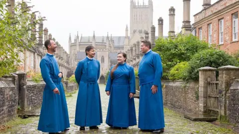 MARK PICKTHALL Members of Wells Cathedral’s Vicars’ Choral stand outside their homes on Europe’s oldest uniquely residential street