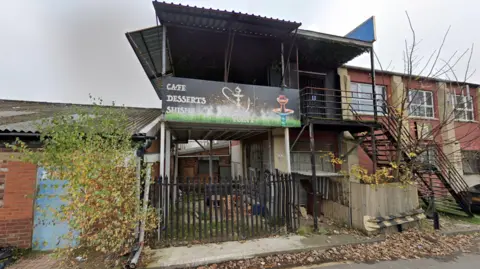 A Google street view image of a two storey former shisha lounge, coloured black, behind 