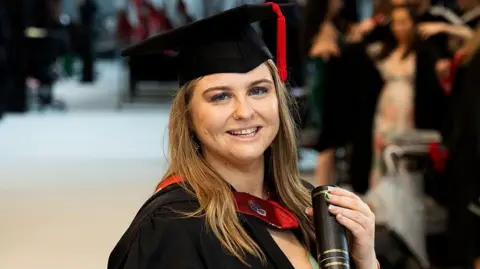 Daniella Taylor in a cap and gown after receiving her degree