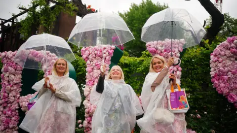 Participants at the Chelsea Flower Show with umbrellas