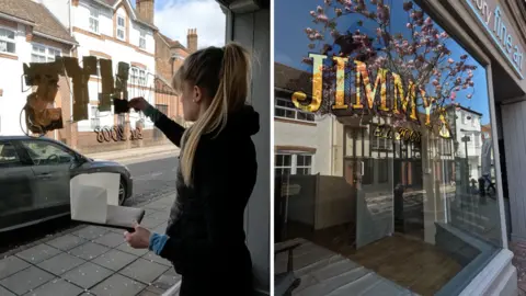 Artful Charlie A composite image showing reverse glass sign painting. On the left is Charlie King wearing a black hoodie with her long blonde hair tied up in a ponytail. She is facing away from the camera, applying gold leaf onto a shop front window from the inside. On the right is the sign as seen from the outside, which reads 'Jimmy's'.