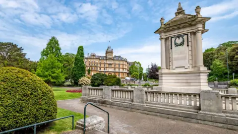 Getty Images Bournemouth war memorial, a white stone monument set in a park. In the background is the town hall.