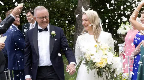 Anthony Albanese and his wife walking back up the isle, with confetti all in the air and they're laughing and smiling