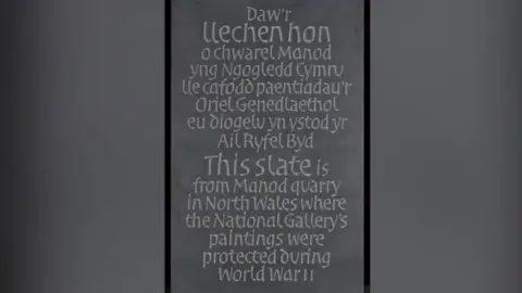 The National Gallery, London A piece of slate, with writing at the top in Welsh. At the bottom is writing in English which reads: "This slate is from Manod quarry in North Wales where the National Gallery's paintings were protected during World War II. 