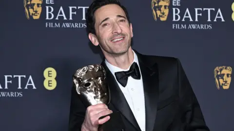 Getty Images Adrien Brody holding his Bafta for best actor for his leading role in The Brutalist