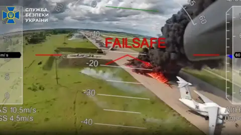 A screengrab of some of the drone footage released by Ukrainian authorities on Wednesday showing a plane in flames at an airfield in Russia