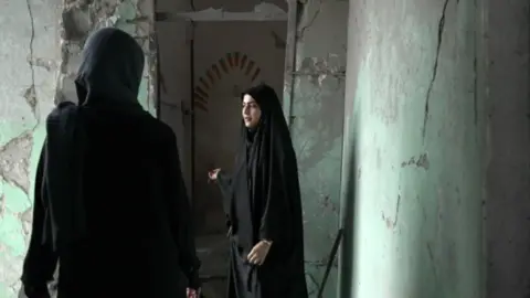 Teacher Amaineh Nademi shows destroyed school