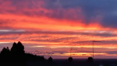 Weather Watchers/Woody's Weather Red skies over the silhouettes of houses
