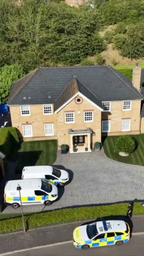 Aerial view of house with police cars outside