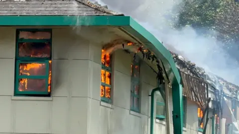 Bennett Motors a close up of the building on fire showing flames in the windows