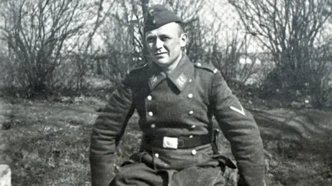 Ute Smeed A man sitting down wearing a German Luftwaffe uniform.