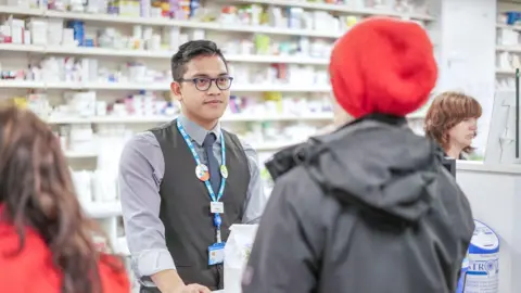 NHS Pharmacist at counter