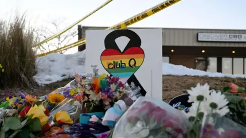 The Denver Post via Getty Images People leaves flowers and other items at a memorial near Club Q where a gunman entered an LGBT nightclub killing at least five people and injuring 25 others on November 20, 2022 in Colorado Springs, Colorado.