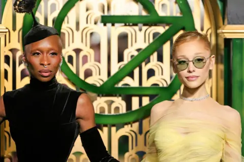 Stars of Wicked, Ariana Grande and Cynthia Erivo, pose on the green carpet for the film.