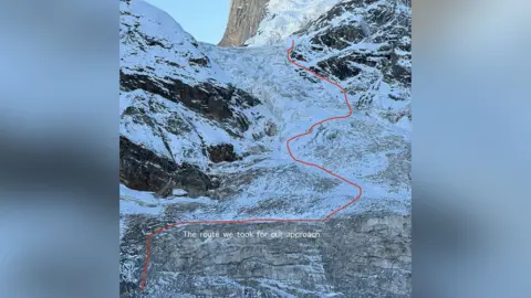 Fay Manners A photo of a steep ice covered mountain face with a red line drawn across it and labelled "the route we took for our approach"