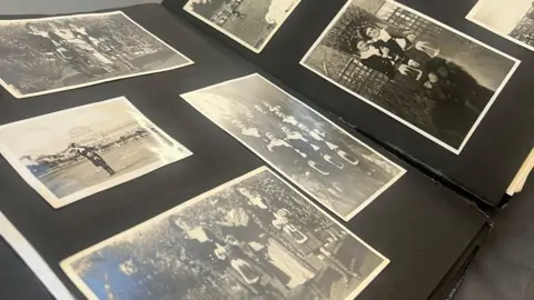 Black and white photos in an album showing the band at many different events and meeting different people