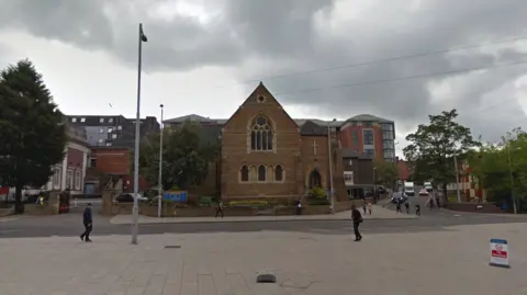 A church building next to a tram line street