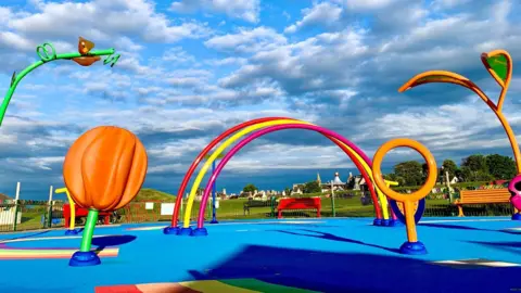 Sam Hey Splashpad is a colourful collection of apparatus.