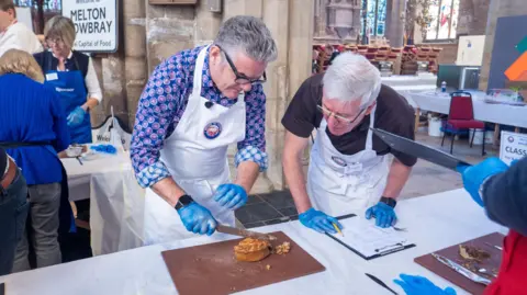 British Pie Awards Two judges cutting a pie with a knife