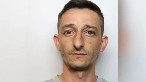 Wiltshire Police A mug shot of Indogen Erdogan. He has short, dark hair and brown eyes.