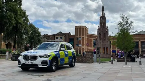 A view of Coventry city centre, with a police car in the foreground.
