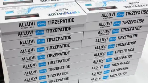 Two tall piles of boxes labeled "TIRZEPATIDE" are stacked on a table