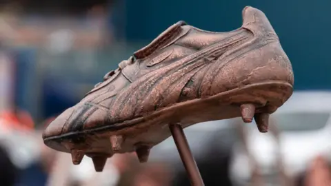 A statue replicating Jimmy Glass's football boot. It has been recreated in a bronze effect and stands on the end of a pole.