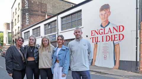 Taylor Atherton's family in front of the mural
