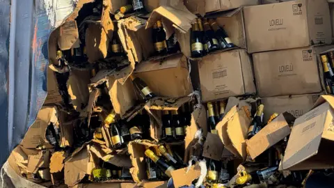 TVP Roads Policing A closer look at the ripped boxes of wine in the back of the trailer.