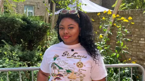 DJ Jada Pink stands in a garden in west London wearing a St Lucia T-shirt during an interview about Notting Hill Carnival.