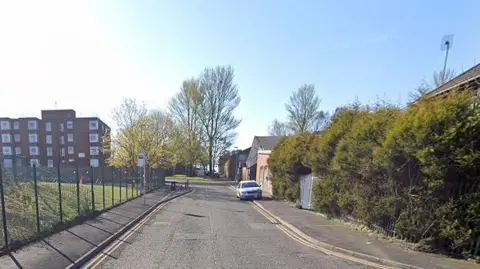 Google Lee Street in Oldham showing a bus stop and flats on the left