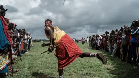 Getty Images A Maasai warrior hurls a wooden throwing club during a sporting event at Kimana, near Kenya's border with Tanzania.