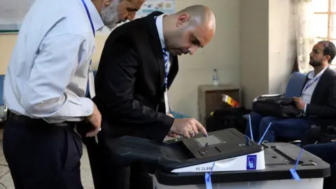 Reuters Iraqi election officials check an electronic vote-counting machine in Baghdad on 12 May 2018