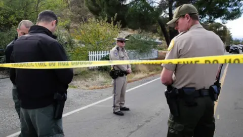 AFP/GETTY Officers stand near one of the crime scenes of the shooting