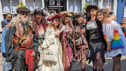 A picture of a group of people dressed as pirates. There is a number of people in the photo.