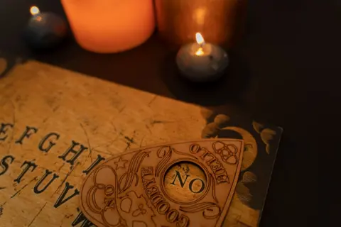 Getty Images A ouija board, with a candle next to it