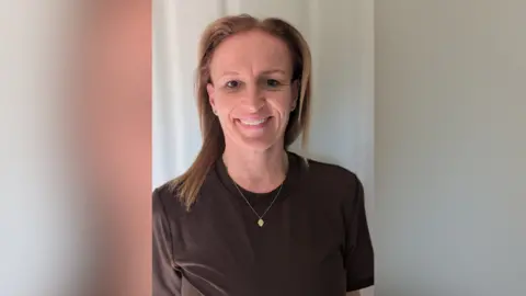 Nicki Fussell A woman smiling into the camera stood against a white backdrop