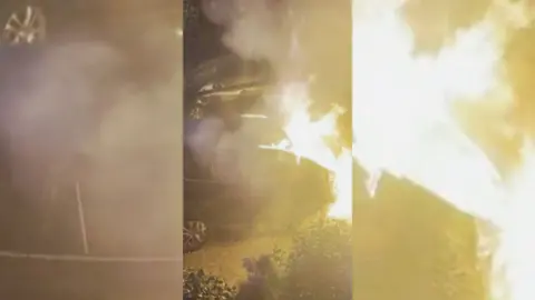 A car on fire on a street