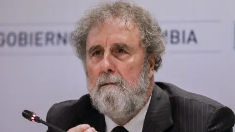 Joaquin Sarmiento/Getty Images Sir Bob Watson sits in front of a mic at climate conference