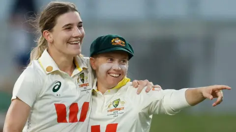 Australia bowler Annabel Sutherland (left) celebrates taking a wicket with captain Alyssa Healy (right)