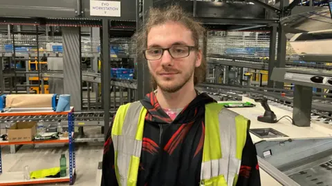 Warehouse worker Gavin Rutter wearing a high-viz jacket 