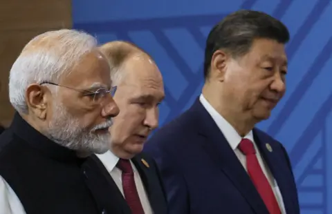 AFP via Getty Images Indian Prime Minister Narendra Modi, Russian President Vladimir Putin and Chinese President Xi Jinping arrive for a family photo during the BRICS summit in Kazan on October 23, 2024.