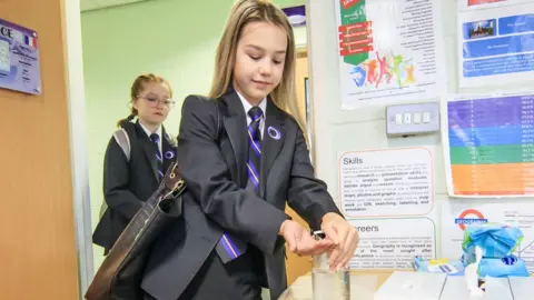 Getty Images girl sanitises hands