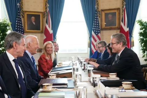 PA A smiling Prime Minister Sir Keir Starmer sits across the table during a meeting with US President Joe Biden in the Blue Room at the White House in Washington DC