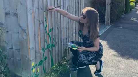 Mair Perkins Mair Perkins painting her fence