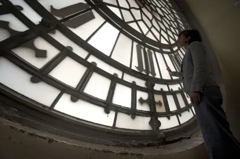 Victoria Jones/ PA A woman inspects a the clock face.