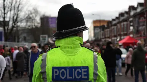 A police officer pictured from behind in a street in Greater Manchester