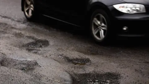 Getty Images Potholes in a UK road