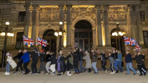 EPA Unionists appeared to dance a conga as they gathered in central Glasgow to celebrate Ms Sturgeon's resignation
